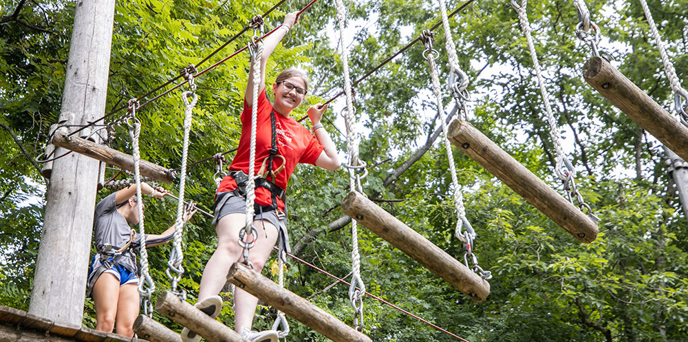 girl-on-rope-bridge Girl walking across swinging rope bridge