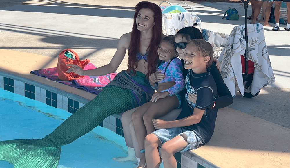 Nsahville Shores Mermaid Family celebrating with arms up in wave pool