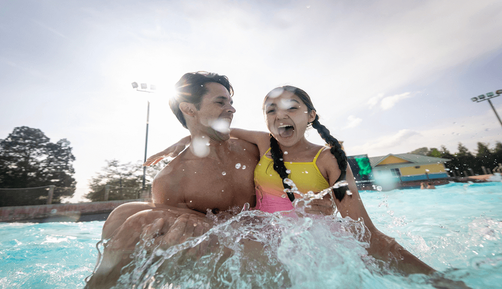 NSH Wavepool - Pai e Filha Família comemorando com os braços erguidos na piscina de ondas